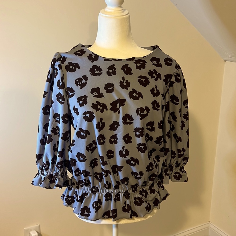 Beautiful brown printed blouse on blue background.